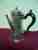 a silver coffee pot with duty dodgers marks