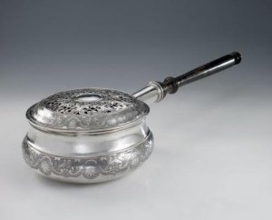 silver bed warmer of circular shape with ebonized turned wood handle, large chiselled band on the body and on the lid